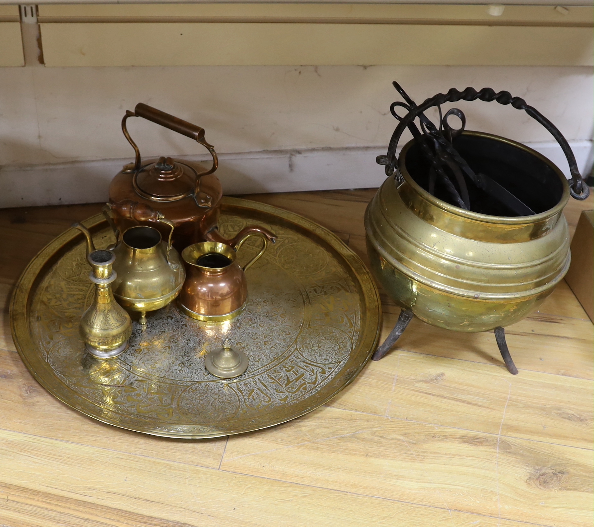 A brass cauldron shaped coal scuttle, a large circular tray, two kettles, a jug and a vase, tray 65cm diameter